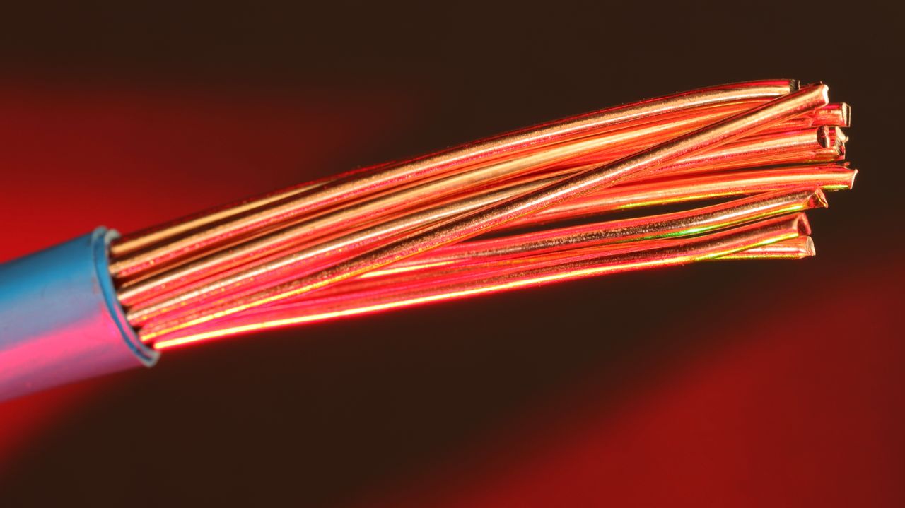 hero-img-01 Detailed image of copper wires illuminated by red light, highlighting texture and color.